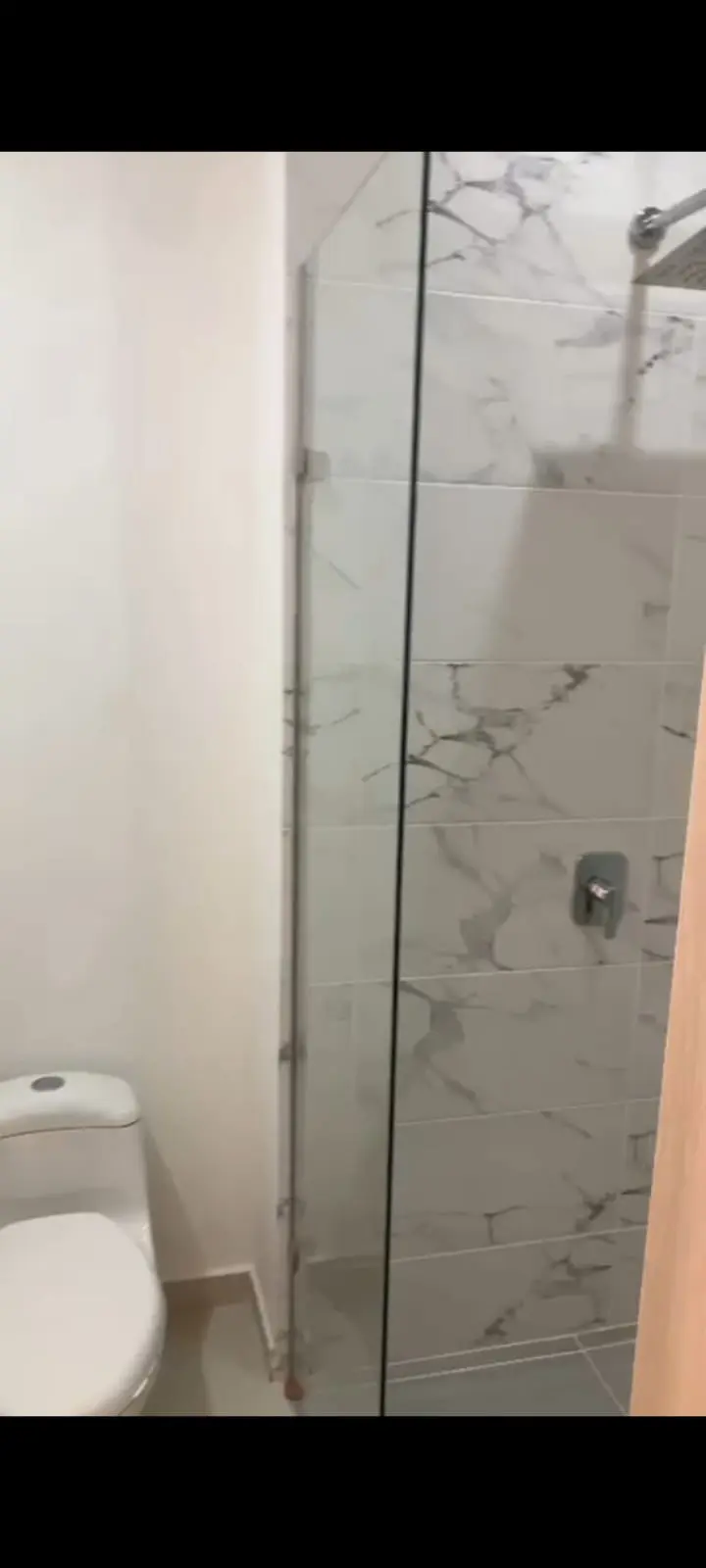 Baño con división de ducha en vidrio
